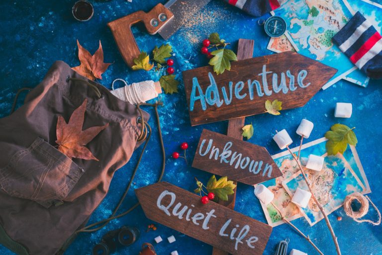 Road sign with Adventure, Unknown and Quiet Life directions. Travel essentials creative header